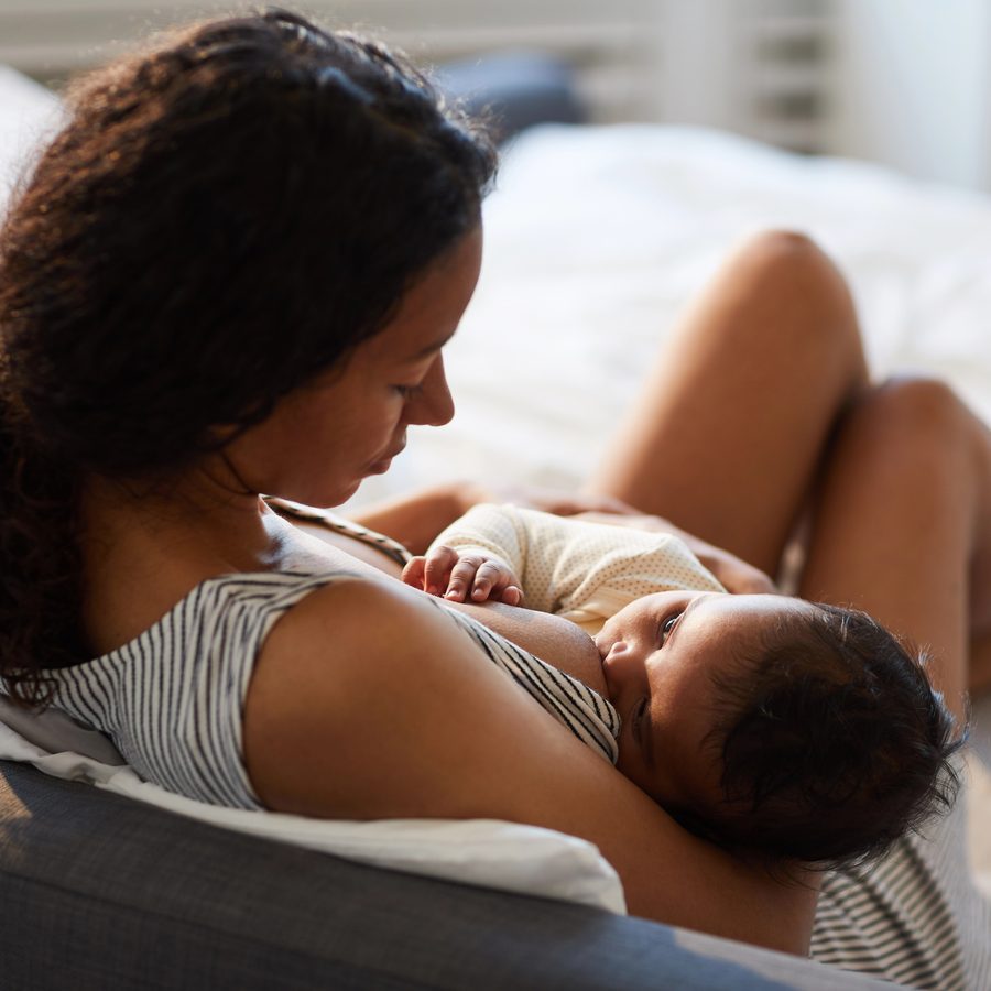 Maman allongée allaitant son nouveau-né
